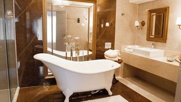 A modern bathroom with a freestanding bathtub, a large mirror, and a vanity with a sink.