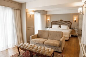 Relax in comfort with a tufted headboard bed, plush sofa, and ornate bench.