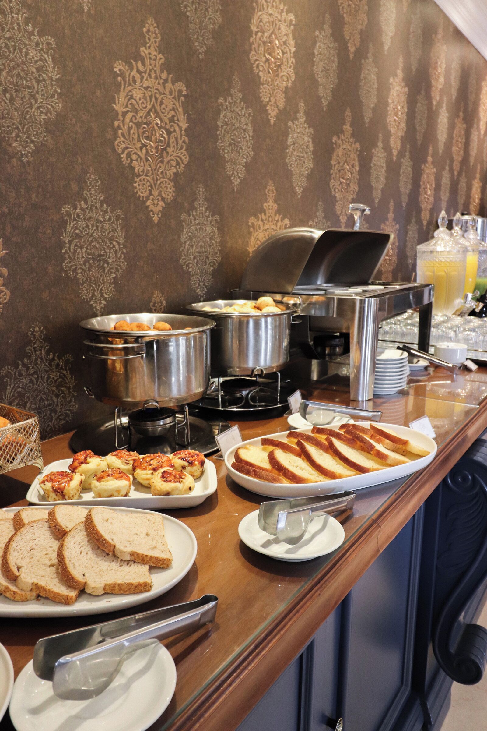 A buffet setup with various food items and utensils.