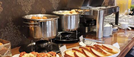 A buffet setup with various food items and utensils.