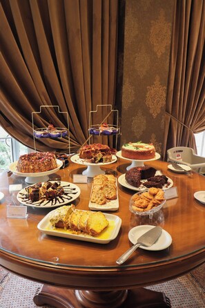 Desserts are served on a table near a large window.