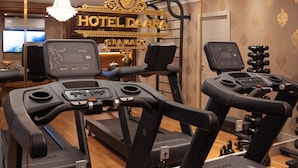 A hotel fitness center with treadmills, a weight bench, and a television screen. - Daara Transamerica Collection Gramado (Gramado)