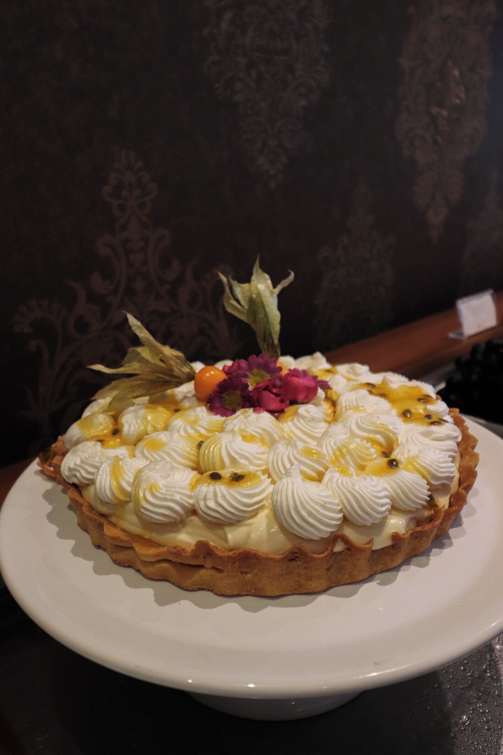 A dessert on a white plate with a decorative design on the background wall.