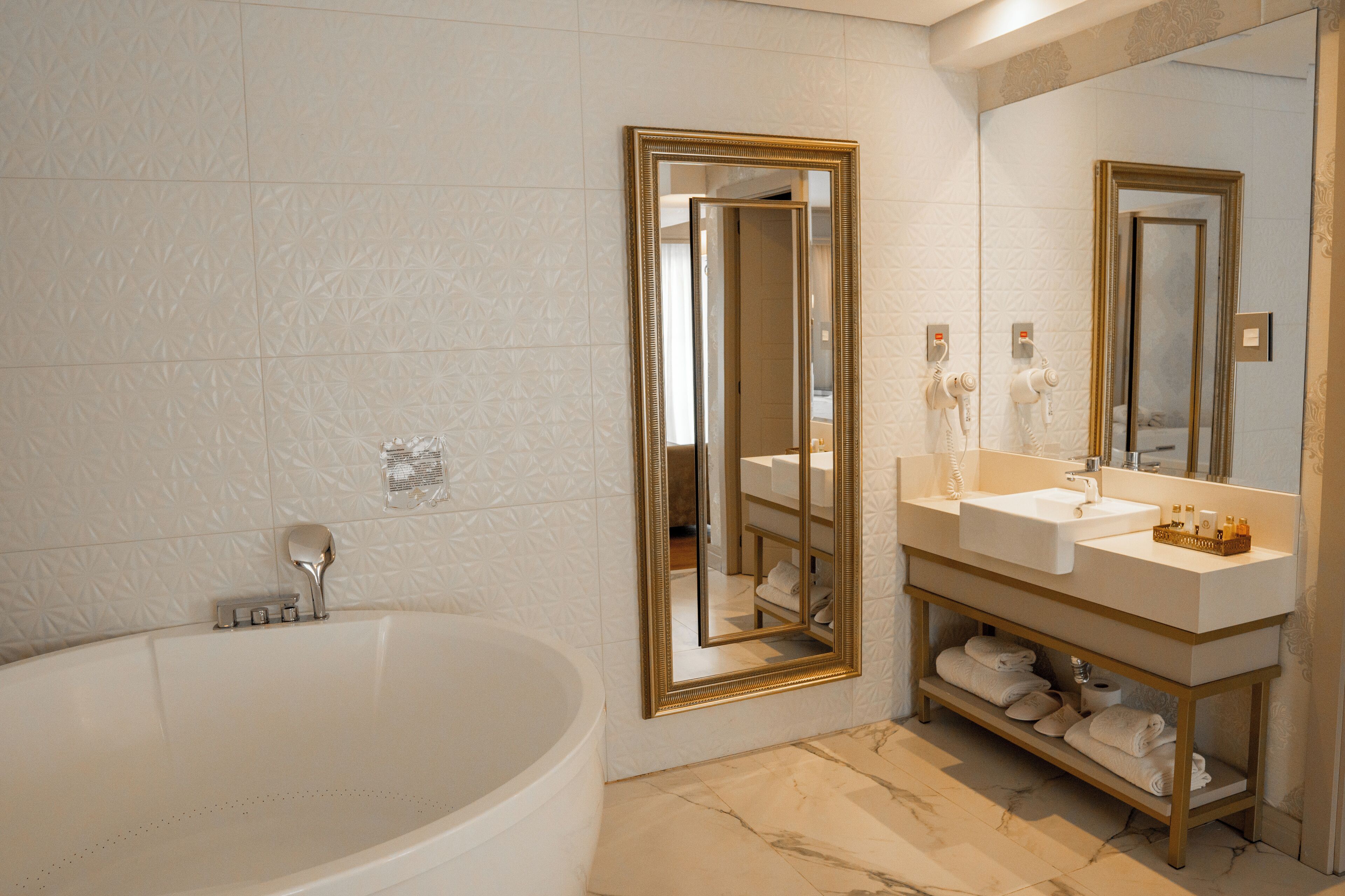 A modern bathroom with a freestanding bathtub, a vanity with a double sink, and a large mirror.