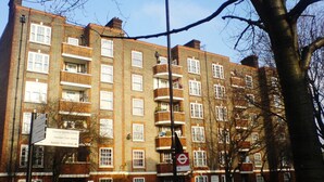 A multi-story residential building with a brick facade, multiple windows, and balconies. - Stylish 2 Bed Between Camden Town & Primrose Hill (London)