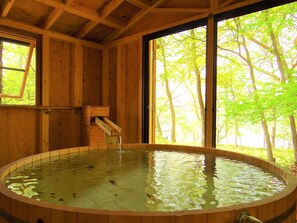 A wooden cabin with a hot tub, large windows, and a wooden ceiling. - Wakkanupuri (Teshikaga)
