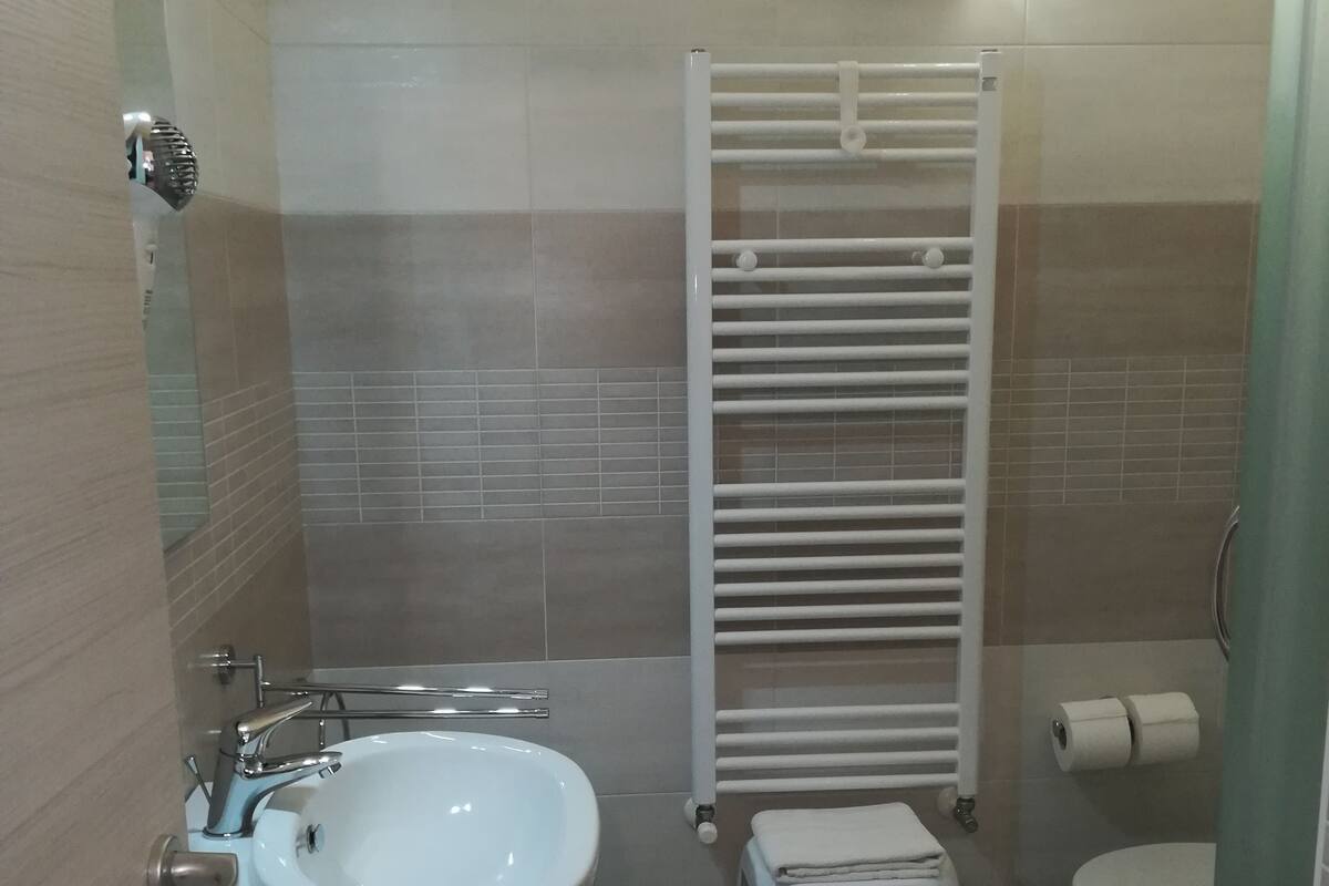 A bathroom with a sink, toilet, and towel rack.