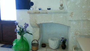 A stone fireplace with a shelf above it holding decorative items. - B&B Demetra (Carovigno)