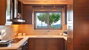 Una cocina moderna con un amplio ventanal, armarios de madera y electrodomésticos de acero inoxidable.