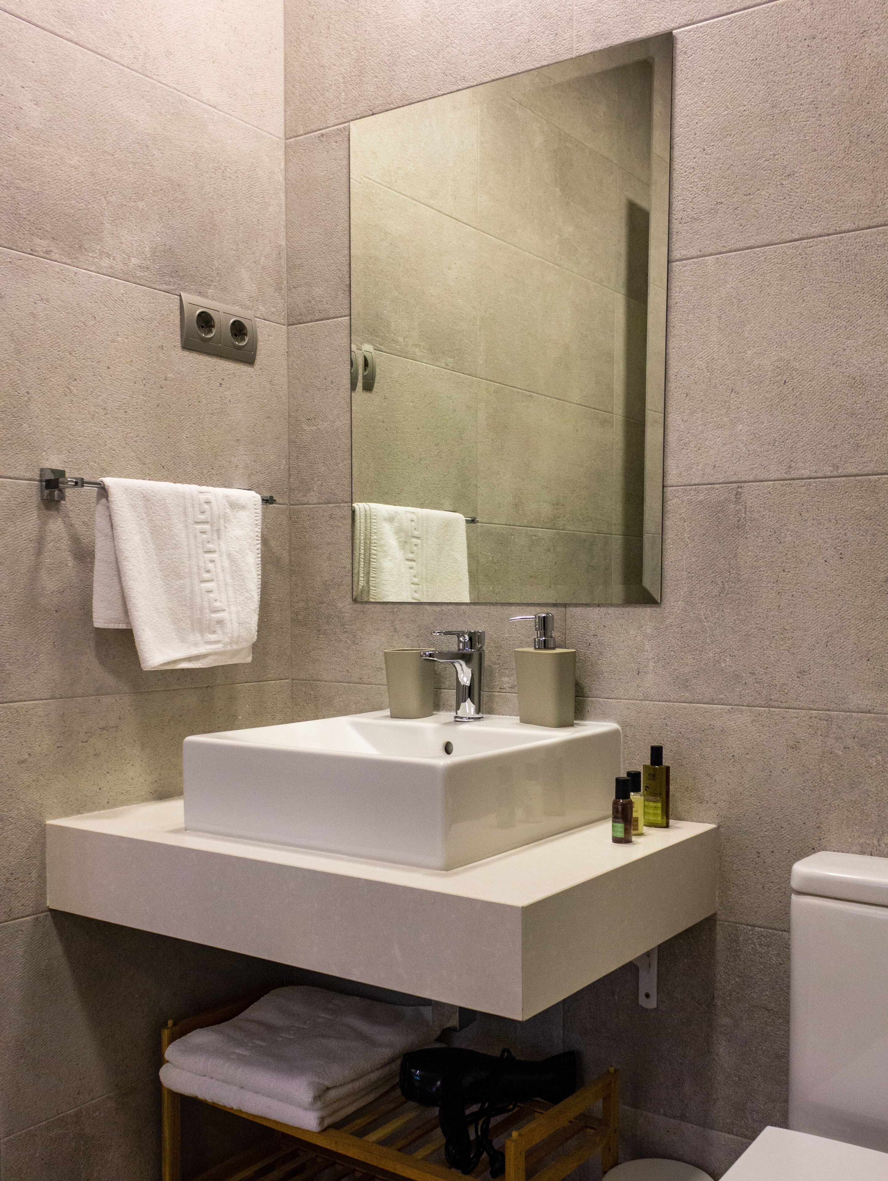 Ein modernes Badezimmer mit Waschbecken, Spiegel und Handtuchhalter.