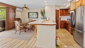 Una cocina moderna con una isla central, armarios de madera y electrodomésticos de acero inoxidable.