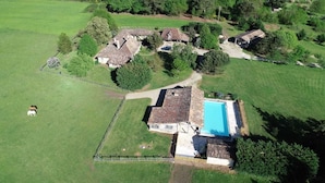An aerial view of a rural property with multiple buildings, a fenced area, and a swimming pool. - Domaine de la Mouthe (Saint-Remy)