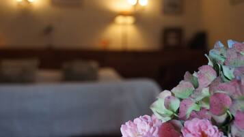 A room with a bed, a lamp, and a bouquet of flowers.