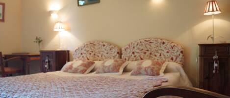A bedroom with a bed, two bedside lamps, a nightstand, and a chair.
