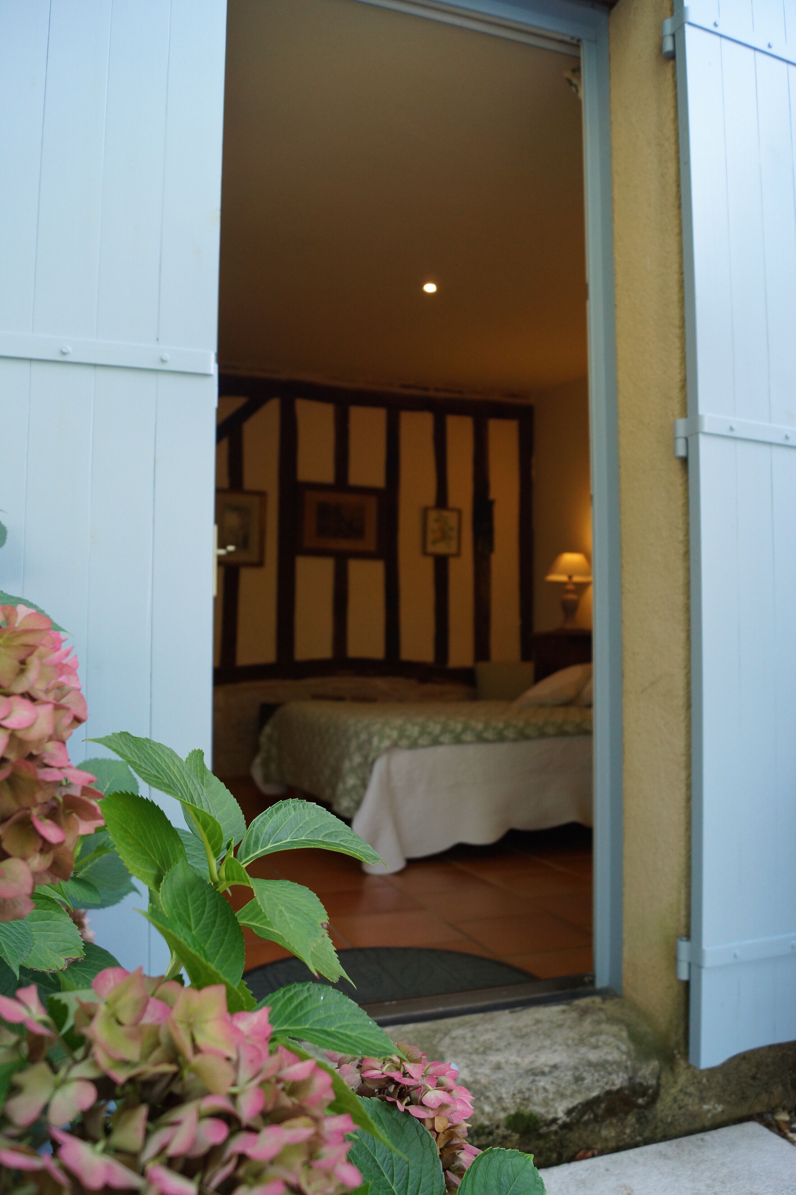 A bedroom with a bed, a nightstand, and a lamp.