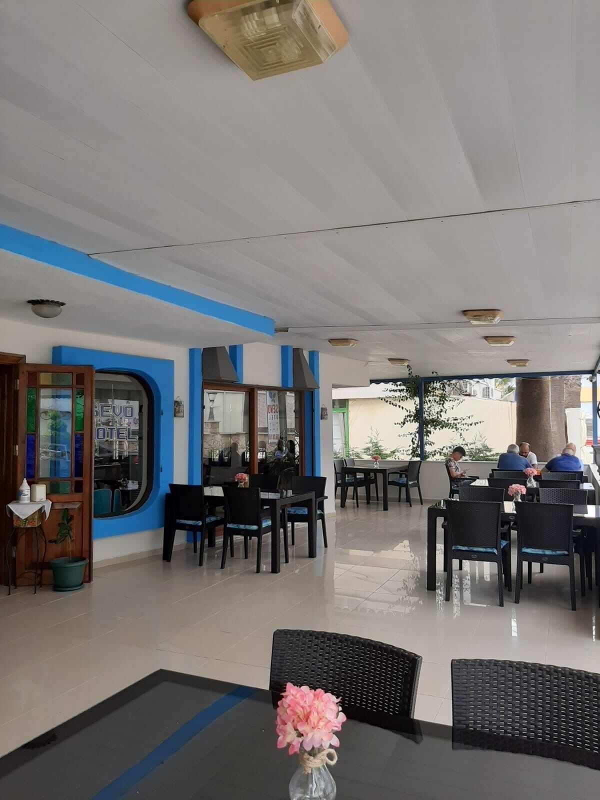 Un restaurante con terraza, entrada visible y ventana con vistas.