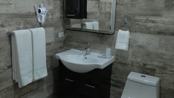 A bathroom with a sink, mirror, and toilet.