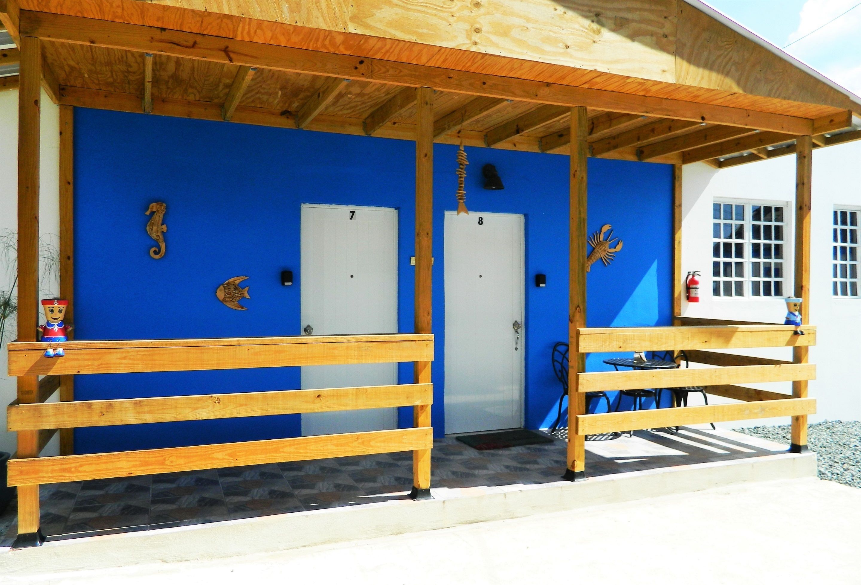 A building with a blue exterior, wooden benches, and numbered doors.