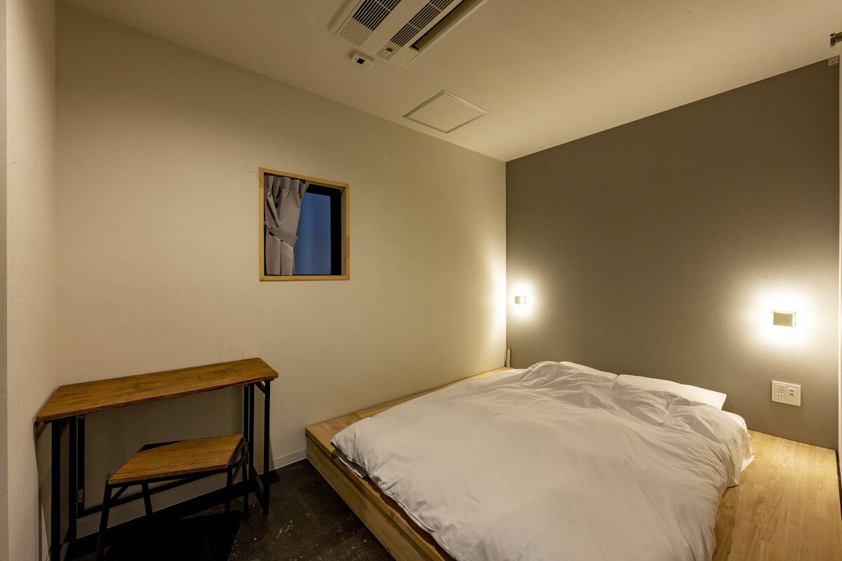 Une chambre à coucher avec un lit, un bureau et une fenêtre.