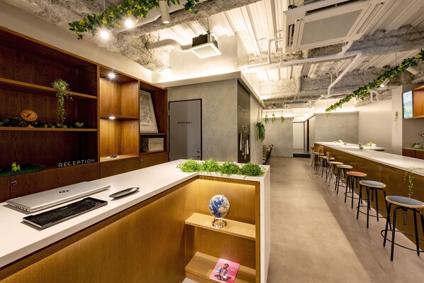 A modern reception area with a reception desk, a 'Staff Only' door, and a bar area with stools. - Plat Hostel Keikyu Minowa Forest (Tokyo)