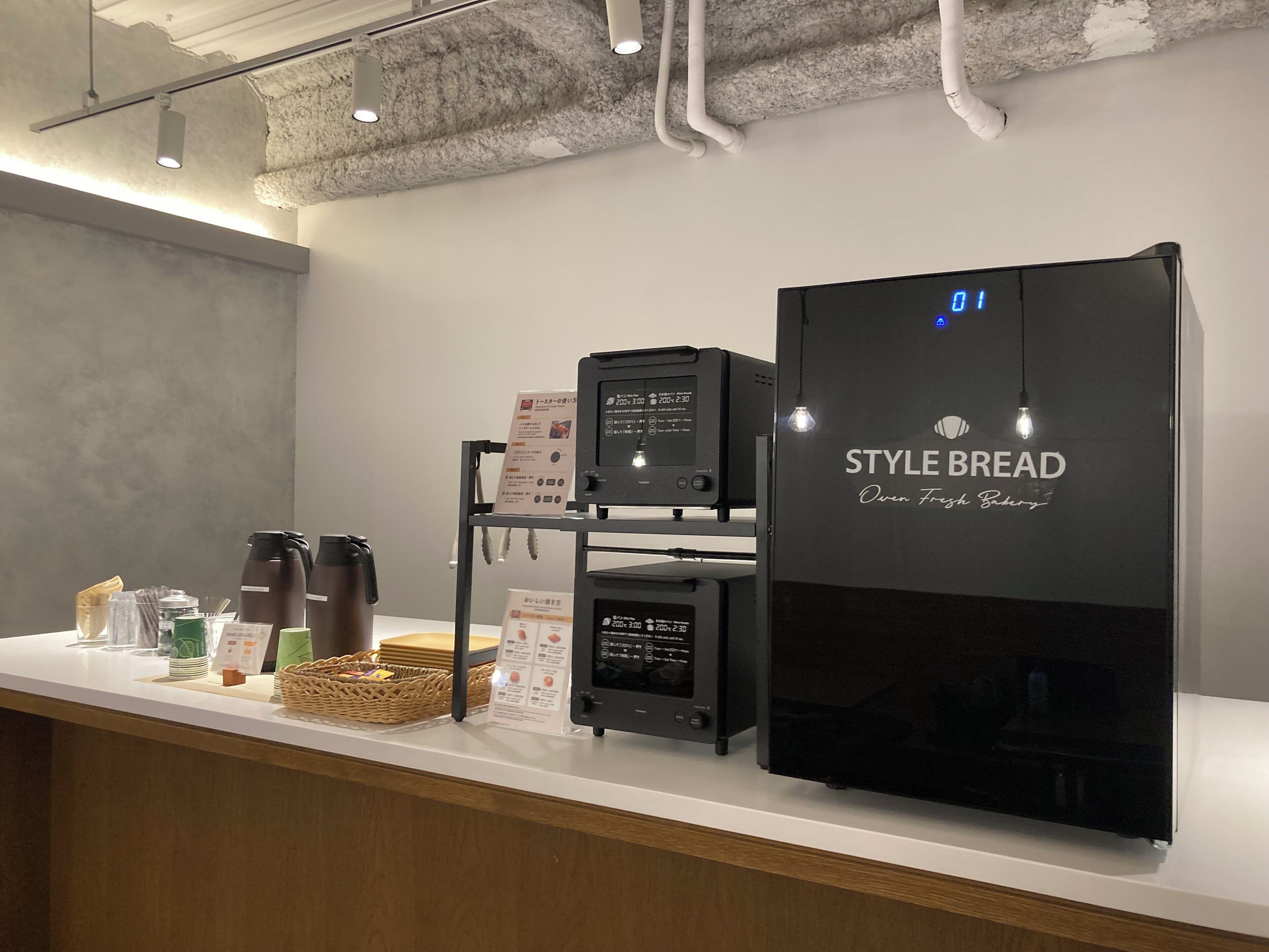 Mostrador de panadería con un horno digital y un refrigerador que dice 'STYLE BREAD Horno Panadería Francesa'.