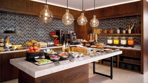 Een moderne keuken met een marmeren aanrecht, houten kasten en een backsplash met een herringbone-patroon.