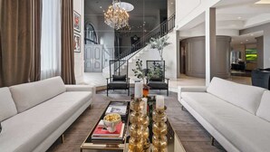 Un salon moderne avec un canapé, une table basse et un lustre.