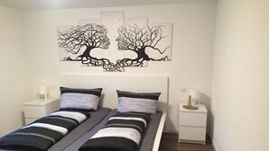 A double bed with a white frame, two nightstands, and a wall art piece above the bed.