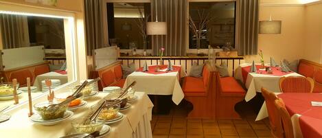 Un comedor con varias mesas y cabinas, cada una con platos, tazones y cubiertos.