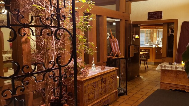 A reception area with a wooden reception desk, a mirror, and a sign indicating the room number. - Hotel Fröhlich (Kaiserslautern)