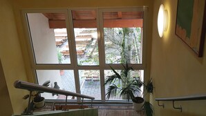 A room with a large window, a metal handrail, and a potted plant. - Hotel Fröhlich (Kaiserslautern)