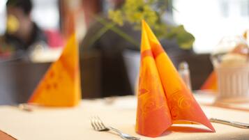 A table with a folded napkin, a fork, and a glass.