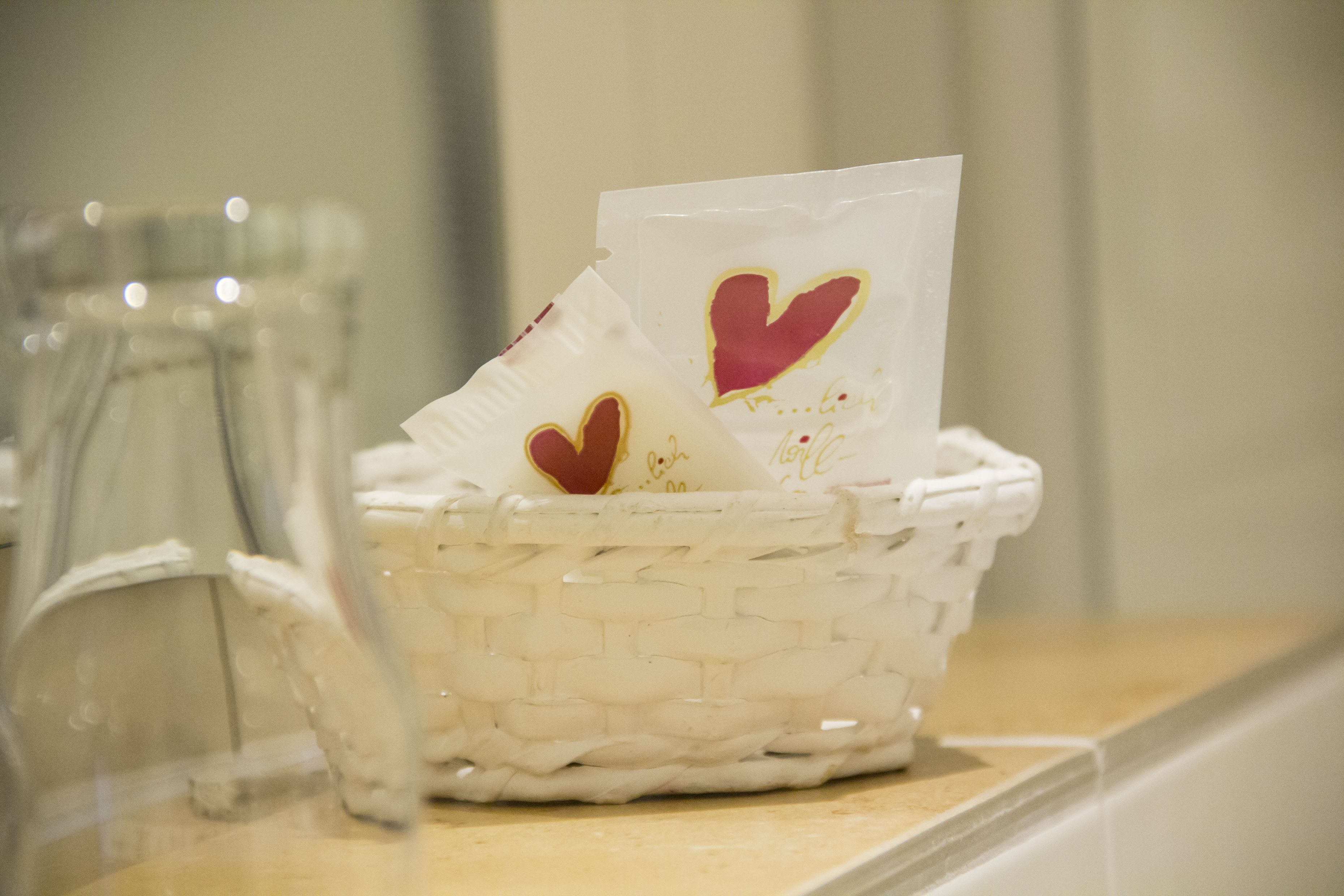 Un panier en osier blanc, avec une carte et un petit objet posés sur un comptoir.