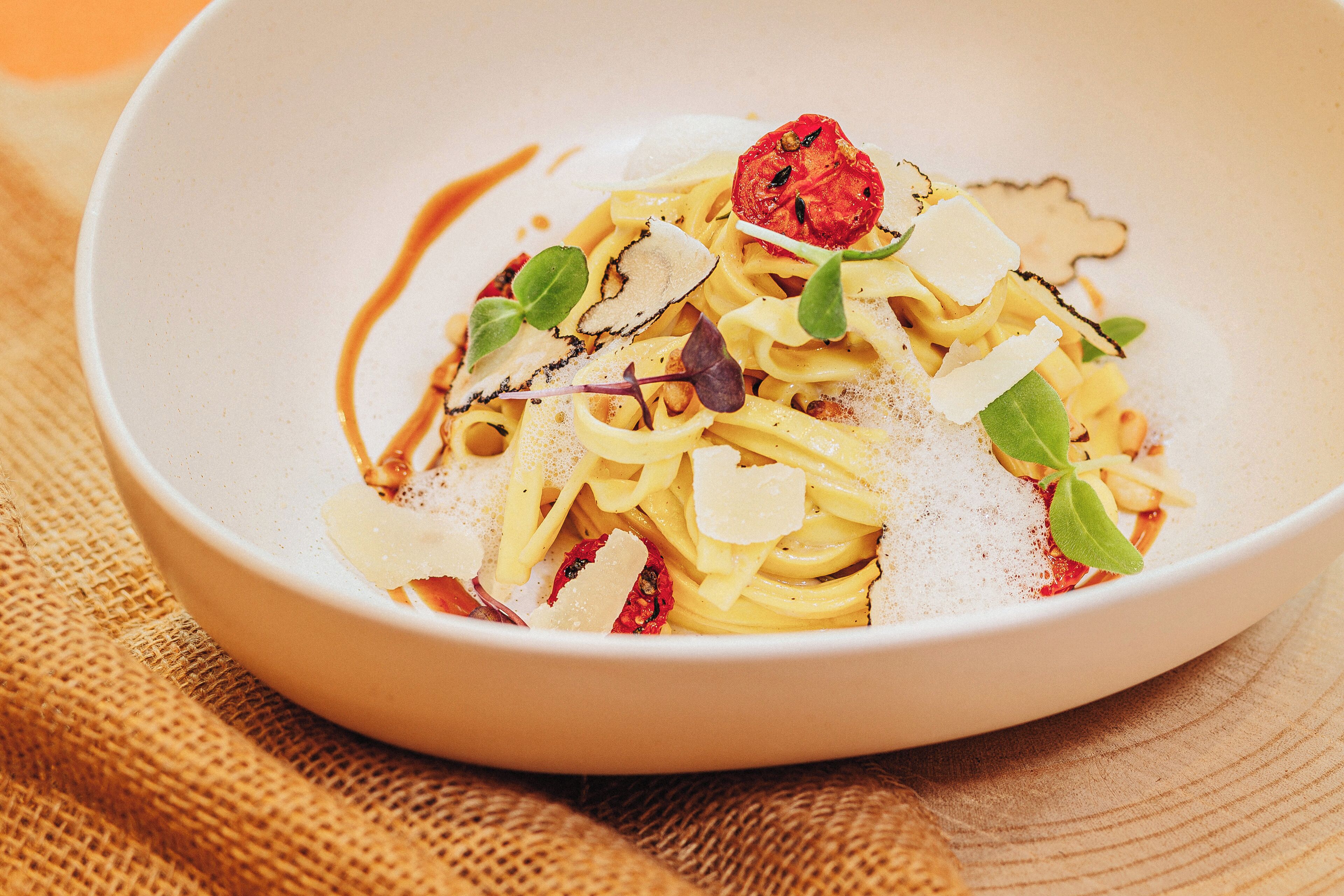 A bowl of pasta with garnishes.
