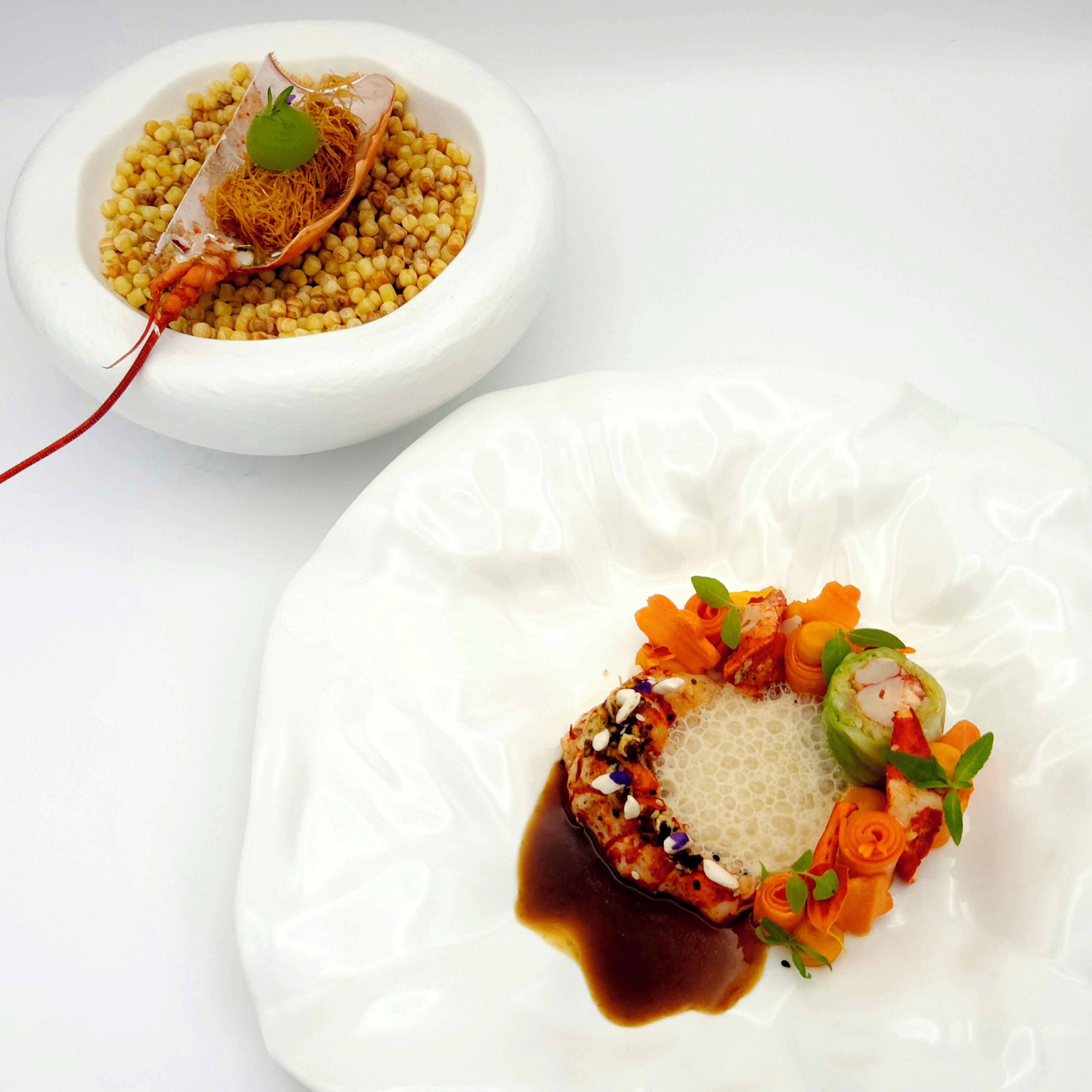 A white plate with a dish featuring a central meat piece, vegetables, and a sauce.