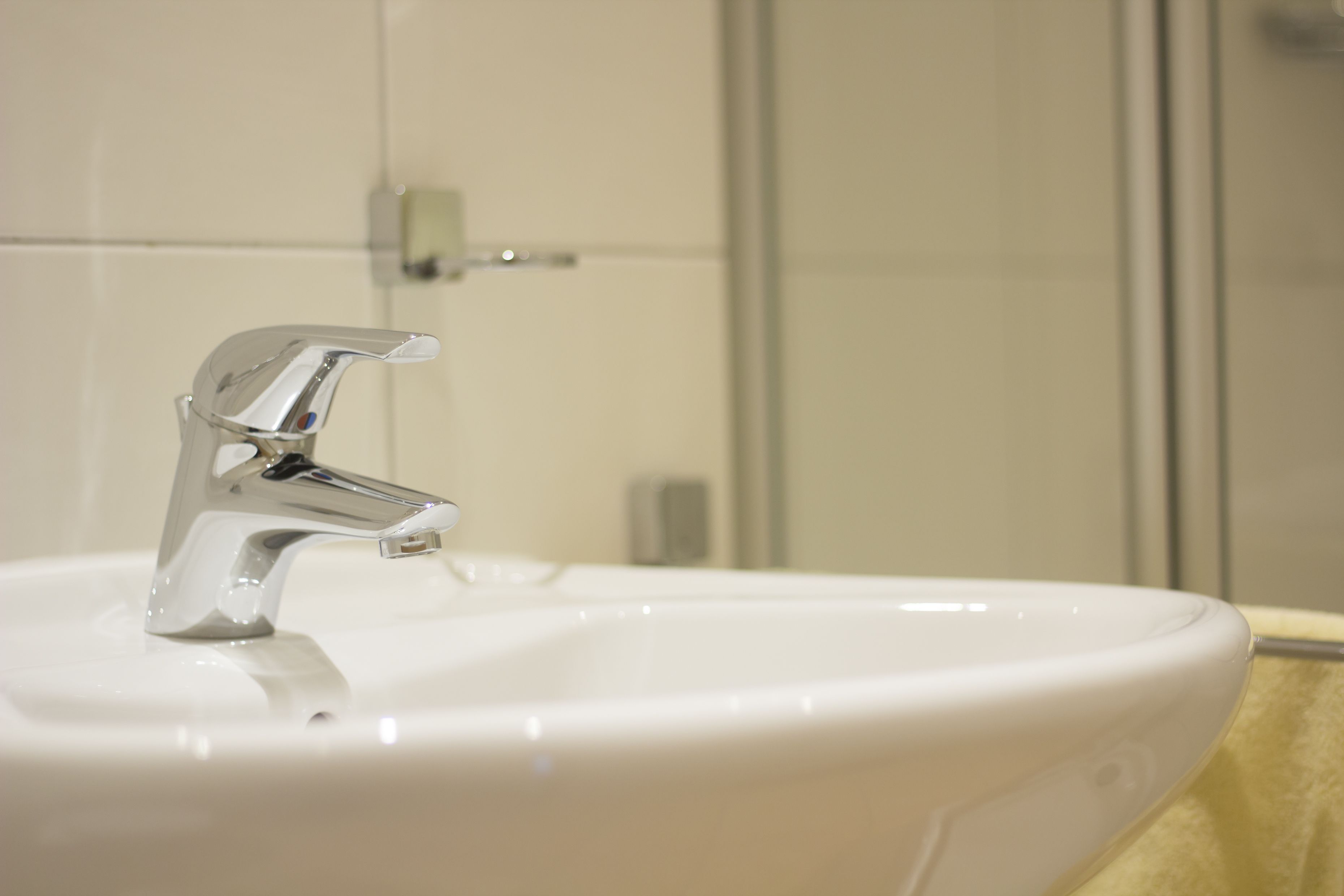 Un lavamanos con grifo cromado y lavabo blanco.