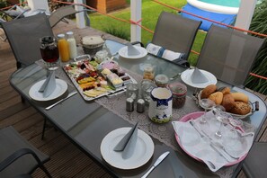 Une table mise pour le petit-déjeuner, avec différents aliments, boissons et ustensiles.