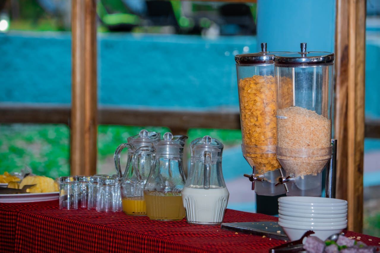 A buffet setup with various food dispensers and condiment pitchers on a table.