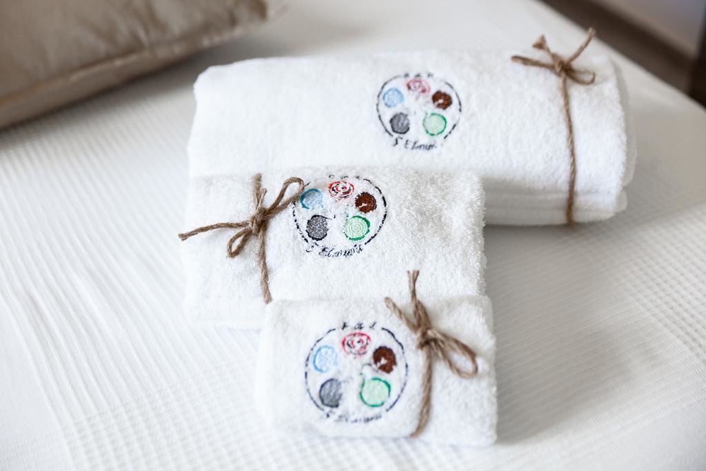 Tres toallas dobladas con logotipos bordados sujetas con hilo.