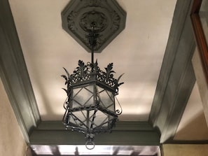 Una linterna hexagonal colgada del techo, sobre la que se aprecia un diseño decorativo.