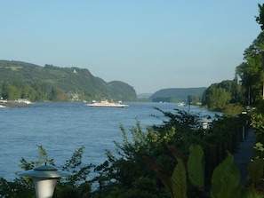 A river with boats, surrounded by greenery and hills. - Hotel Niederée (Bad Breisig)