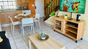 A modern living room with a dining area, a staircase, and a kitchen. - Cozy One Bedroom Lakefront Villa Close to the Attractions (Orlando)