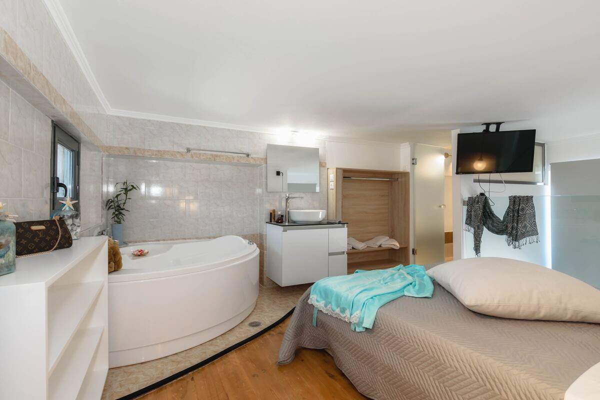 A modern bathroom with a freestanding bathtub, a vanity with a mirror, and a shower area.