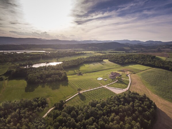 An aerial view of a rural landscape with fields, a small body of water, and a few buildings.