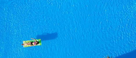 Una piscina al aire libre de temporada, sombrillas