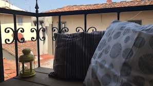A balcony with a railing, a lantern, and two cushions. - Vecchia Volta (Florence)