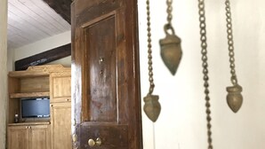 A wooden door with a brass bell and chain hanging from the ceiling. - Vecchia Volta (Florence)