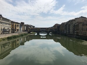 A calm river with a bridge in the center, surrounded by historic buildings with balconies. - Vecchia Volta (Florence)