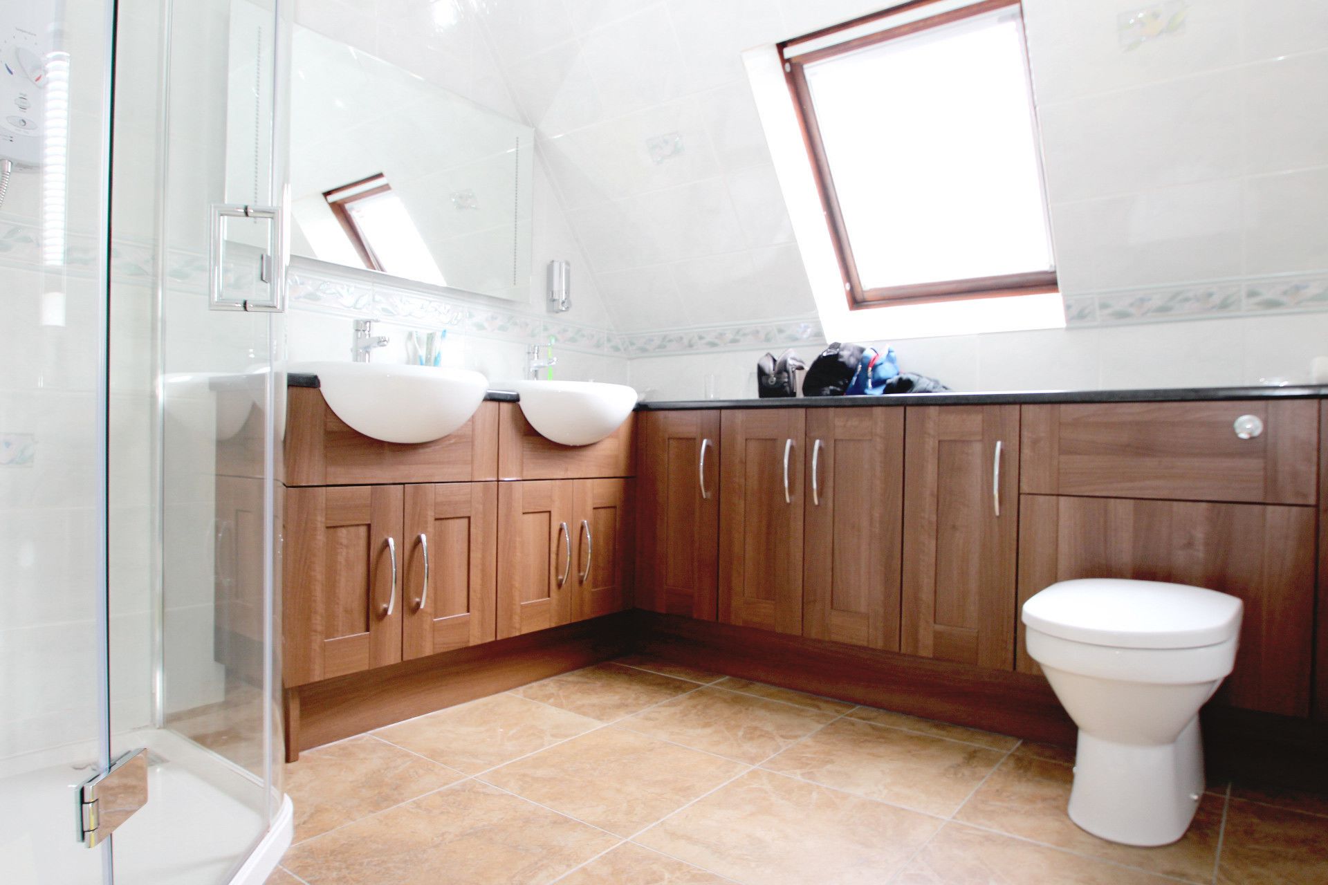 A bathroom with two sinks, a toilet, and a shower.