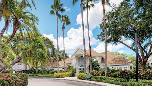 A residential area with a house featuring a front porch, surrounded by palm trees and well-maintained landscaping. - Location! Location! Location!  Sarasota!!! (Sarasota)